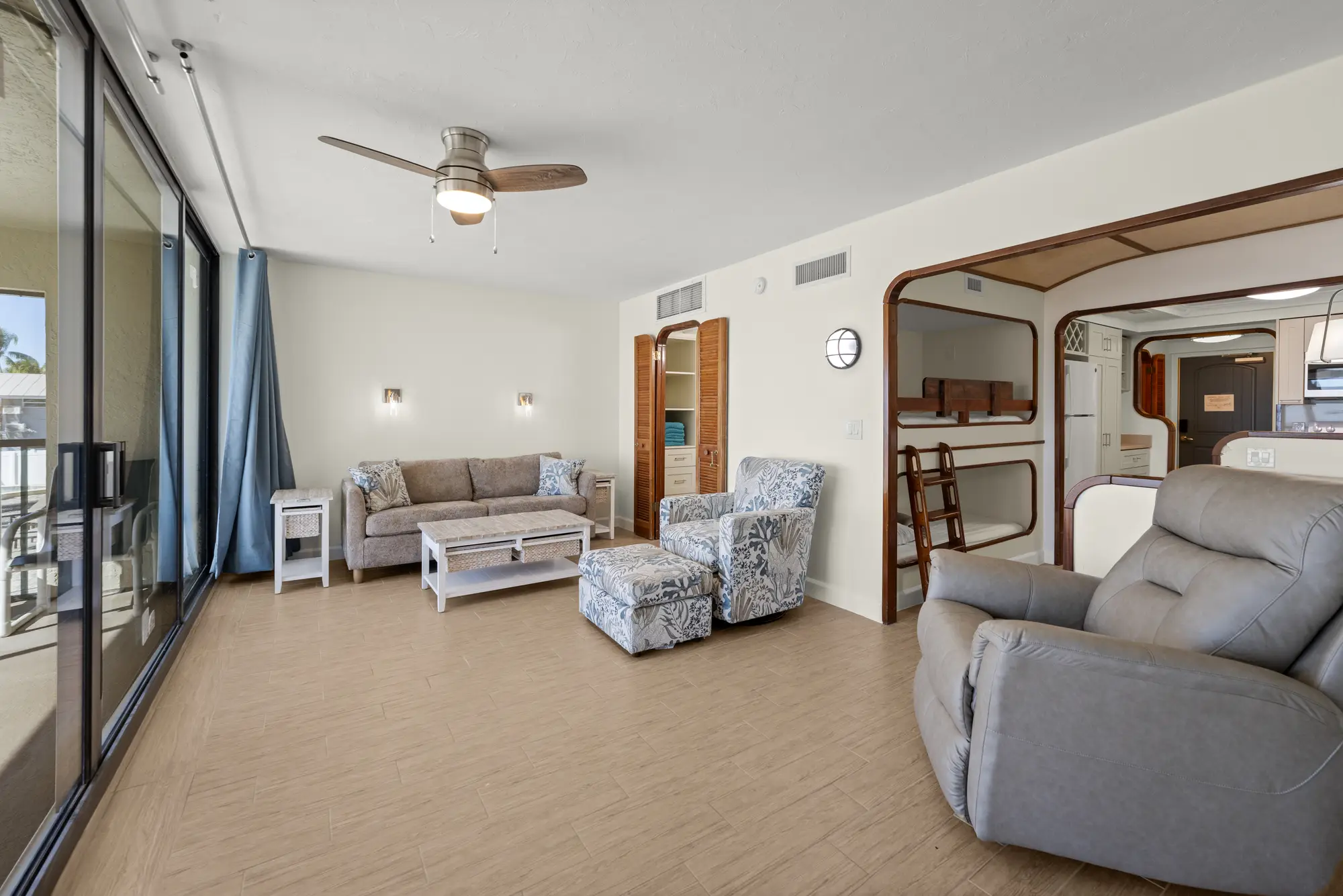 Bright living area with sofa, recliner, and adjacent bunk-bed nook